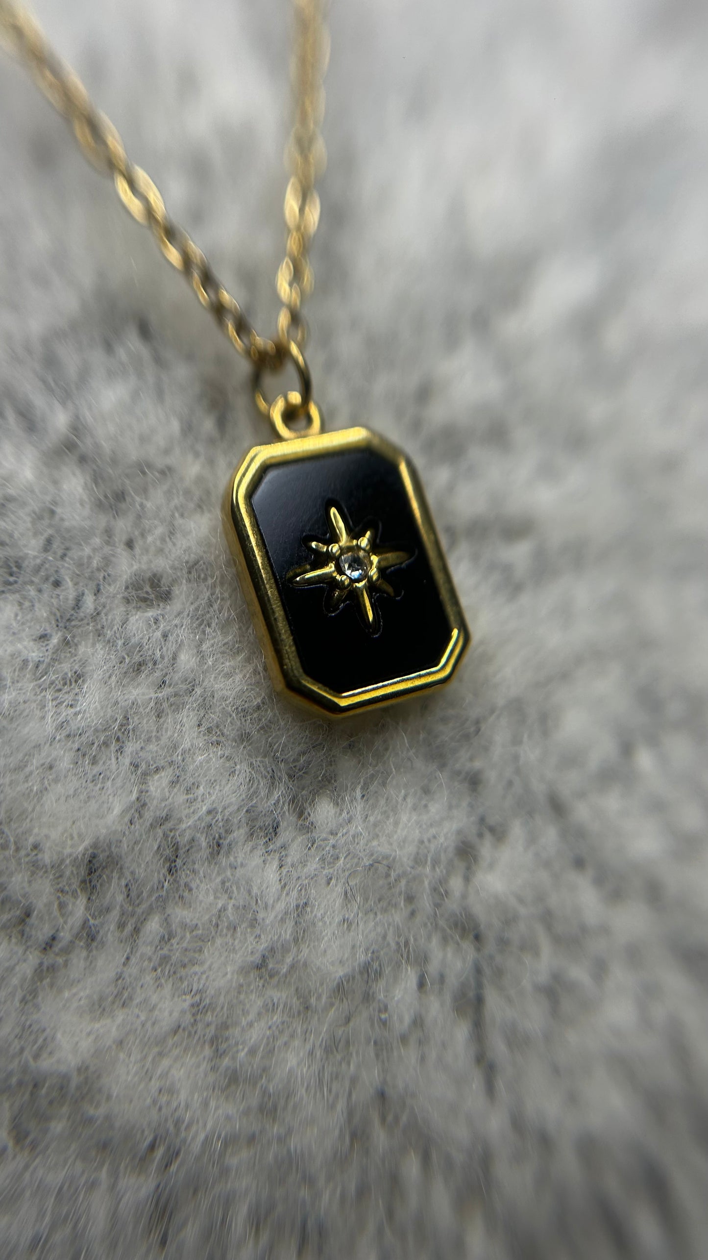Collier en acier inoxydable avec une étoile noire et dorée en pendentif