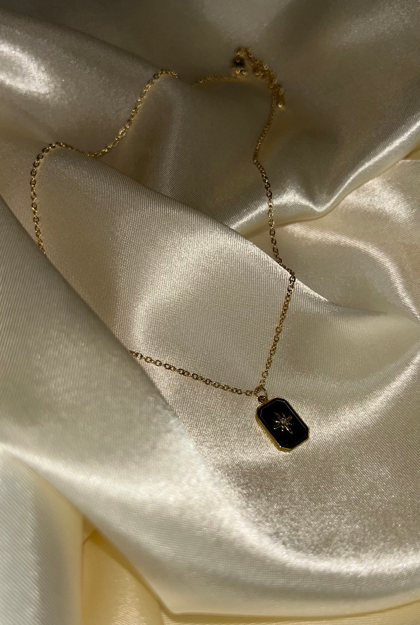Collier en acier inoxydable avec une étoile noire et dorée en pendentif